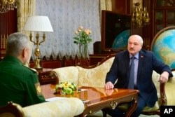 Belarusian President Alexander Lukashenko, right, meets with Russian Defense Minister Sergei Shoigu in Minsk, Belarus, April 10, 2023.