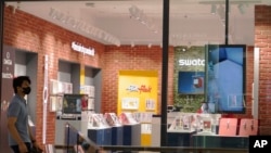 A man walk pass Swatch outlet at a shopping mall in Putrajaya, Malaysia, Aug. 10, 2023. 