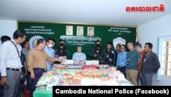 ក្នុង​រូបថត​ចែកផ្សាយ​ដោយ​​អគ្គស្នងការដ្ឋាន​នគរបាល​ជាតិ​ មន្ត្រី​បង្ហាញ​គ្រឿង​ញៀន​ជាង​១០០​គីឡូក្រាម​និង​ជន​សង្ស័យ​៣​រូប​ដែល​ត្រូវ​​បាន​ឃាត់ខ្លួន។ (​​ហ្វេសប៊ុក/អគ្គស្នងការដ្ឋាន​នគរបាល​ជាតិ​)