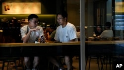 Young people spend time at a mall cafe in Beijing, Aug. 15, 2023. China’s youth unemployment rate reached an unprecedented 21.3% in June, when authorities decided to halt the release of age-related employment data.