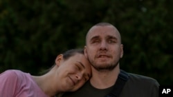 Vlada Ryabets, left, leans on her fiance Ivan Soroka, a 27-year-old former Ukrainian soldier blinded in the war.