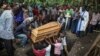 Relatives mourn as the coffin of Florence Masika, who was killed along with her son Zakayo Masereka by suspected rebels as they retreated from Saturday's attack on the Lhubiriha Secondary School, is buried in Nyabugando, Uganda, June 18, 2023. 