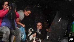 Residents and their pets evacuate a flooded area after heavy rain in Sao Sebastiao do Cai, Rio Grande do Sul state, Brazil, May 2, 2024.