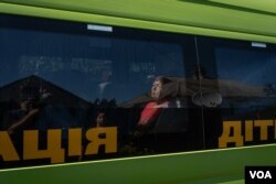 Lydia sits in a bus waiting to be evacuated along with other Kupiansk residents as the battles get closer on Aug. 19, 2023. (Yan Boechat/VOA)