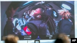 Guests watch a live broadcast from inside Virgin Galactic's rocket-powered plane Unity 22, showing space tourists Anastatia Mayers, 18, and her mother Keisha Schahaff, rear, at Spaceport America, near Truth or Consequences, New Mexico, Aug. 10, 2023.