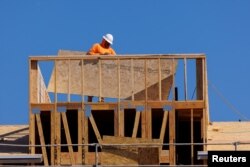 FILE - A worker helps construct a residential homes in Vista, California, Oct. 24, 2023.