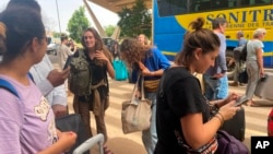 French nationals gather as they wait to be airlifted back to France on a French military aircraft, at the international airport in Niamey, Aug. 1, 2023. 