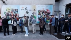 Taiwanese people line up to vote outside a polling station in Taipei, Jan. 13, 2024. Taiwanese are voting Saturday for a new president in an election that could chart the trajectory of its relations with China over the next four years.