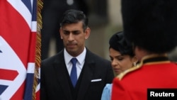 Perdana Menteri Inggris Rishi Sunak dan istrinya Akshata Murty tiba di acara penobatan Raja Charles di Westminster Abbey, London, pada 6 Mei 2023. (Foto: Reuters/Henry Nicholls)