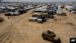 FILE - Kurdish forces patrol al-Hol camp, which houses families of members of the Islamic State group in Hasakeh province, Syria, April 19, 2023.