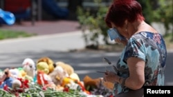 A woman reacts at a makeshift memorial to victims of what Russian authorities say was a Ukrainian missile strike, in Sevastopol, Russian-occupied Crimea, June 24, 2024. 