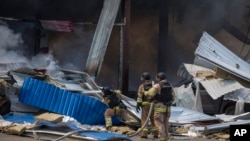 Nhân viên cứu hỏa dập lửa sau khi một quả tên lửa đánh trúng một siêu thị ở Ukraine hôm 9/8.