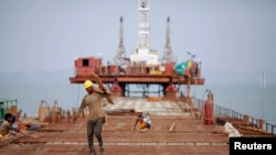 FILE - Construction of new port at the Kaladan River in Sittwe, Myanmar, May 19, 2012. The giant arms of a half-built wharf enfold the estuarine mud with steel and concrete.