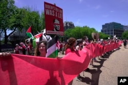 Pro-Palestinian protesters carry a red banner representing a "red line" in front of the White House in Washington, June 8, 2024.