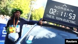 Gold medalist Ethiopia's Tigist Assefa poses next to a time board after winning the women's Berlin Marathon, Sept. 24, 2023.