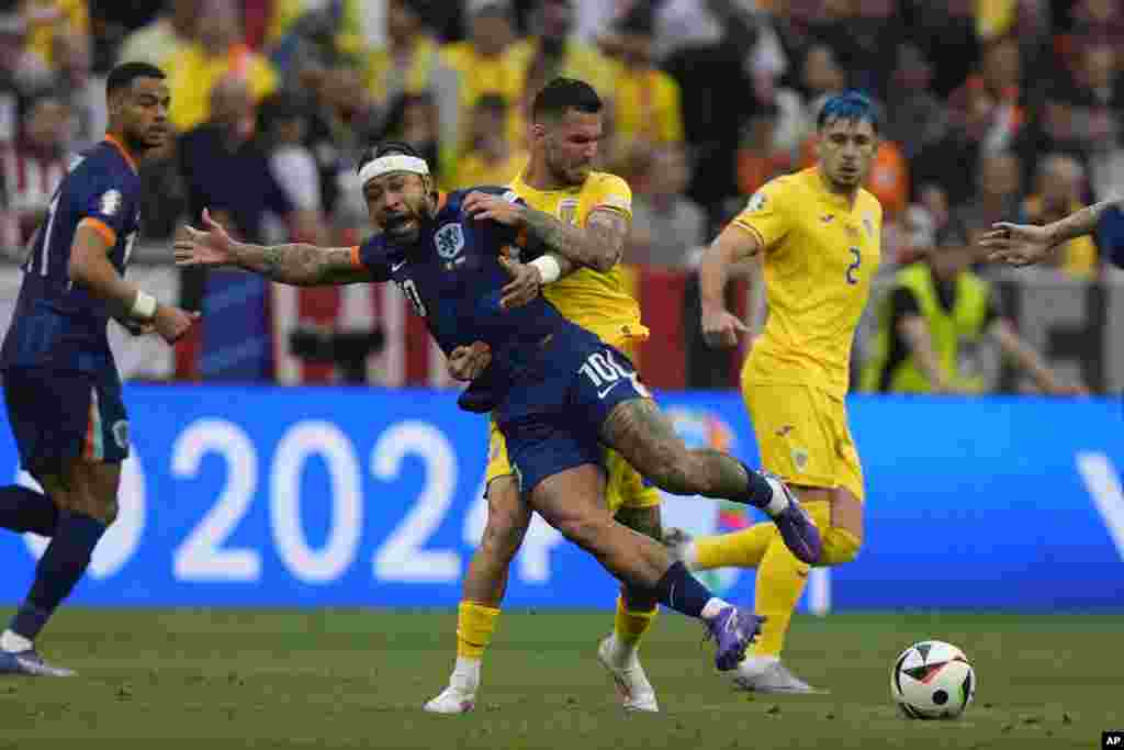 Memphis Depay of the Netherlands (10) is challenged by Romania's Marius Marin during a round of sixteen match between Romania and the Netherlands at the Euro 2024 soccer tournament in Munich, Germany.