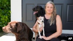 Amy Chadwick poses at her current home with her pets, April 8, 2024, in Satellite Beach, Fla.