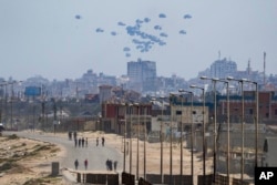 An aircraft airdrops humanitarian aid over the northern Gaza Strip, as seen from central Gaza, April 30, 2024.