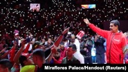 Venezuela's President Nicolas Maduro waves to supporters after saying he's running for another term in the July 28, 2024 election, at the Poliedro de Caracas, Venezuela, March 16, 2024.