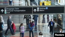 Algunos viajeros con máscaras transitan por el Aeropuerto Nacional Ronald Reagan de Washington, en Arlington, Virginia, EEUU, el 19 de abril de 2022.