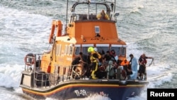 FILE - Rescue personnel bring migrants ashore after their boat sunk in the English Channel, near Dover, Britain, Aug. 12, 2023, in this photo obtained from social media. (Stuart Brock/via Reuters)