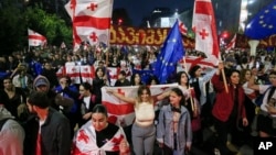 Demonstrators with Georgian national and EU flags rally during an opposition protest against a foreign influence bill as they mark their country's Independence Day, in the center of in Tbilisi, Georgia, May 26, 2024.