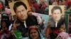 FILE - Supporters of Pakistan's former prime minister Imran Khan carry placards displaying a portrait of Khan in Karachi, March 19, 2023. Pakistan's political and judicial crisis began with Khan's removal from office in a parliamentary vote of no-confidence last April.