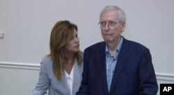 FILE - Robbin Taylor, an aide to U.S. Sen. Mitch McConnell, R-Ky., joins McConnell while he speaks at the Madison Event Center, Aug. 30, 2023, in Covington, Kentucky. McConnell appeared to briefly freeze up, weeks after he had a similar episode in Washington.