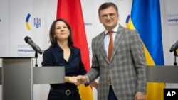 Menteri Luar Negeri Jerman Annalena Baerbock (kiri) berjabat tangan dengan Menlu Ukraina Dmytro Kuleba selama kunjungannya ke Kyiv, Ukraina Senin (11/9). 