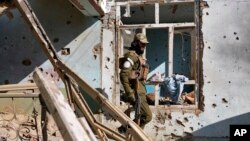 FILE - A Taliban fighter checks an Islamic State group house that was destroyed in the ongoing conflict between the two in Kabul, Afghanistan, Jan. 5, 2023. Taliban raided an Islamic State hideout in the capital, Feb. 14, 2023.