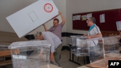 Teachers prepare ballot boxes and cardboard voting booths at a school in Antakya, Turkey, May 13, 2023, where voting will take place in presidential and legislative elections May 14.