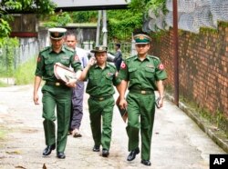 FILE - Myanmar military officers walk toward a township court during a trial of journalist Kyaw Min Swe, in Yangon, Myanmar, June 23, 2017.