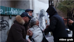 Trenutak kada neidentifikovani ljudi, za koje se kasnije ispostavilo da su policajci u civilu, privode antiratnu aktivistkinju Aidu Ćorović, nakon što je jajima gađala mural haškog osuđenika generala Ratka Mladića, u centru Beograda, 9. novembra 2021 (Foto: Videogreb)