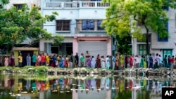 People queue up to vote outside a polling booth during the fifth round of multi-phase national election in Howrah, India, May 20, 2024.