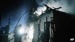 Petugas penyelamat memadamkan api di sebuah rumah yang rusak akibat serangan drone Rusia di lingkungan perumahan di Kharkiv, Ukraina, pada 4 April 2024. (Foto: AP)