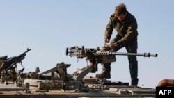 An Israeli soldier checks a weapon in the Israel-annexed Golan Heights near the border with Syria, Dec. 28, 2023. The Israeli army said Saturday that it was carrying out strikes in Syria after two rockets fired from Syria fell into territory under Israel's control.  