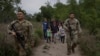 Beberapa migran China, yang berbaur dengan migran Amerika Tengah, dikawal oleh anggota Garda Nasional Angkatan Darat Texas setelah kelompok itu diselundupkan menyeberangi sungai Rio Grande dari Meksiko di Fronton, Texas (foto: dok). 