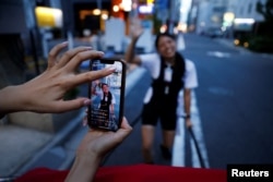 Rickshaw drivers Akina Suzuki (right), 19, and Misato Otoshi, 30, live stream on social media to promote their activities, at the Asakusa district in Tokyo, Japan, August 17, 2023.
