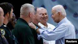 U.S. President Joe Biden speaks with a man as he visits Suwannee Pineview Elementary School during his tour of Hurricane Idalia storm destruction in Live Oak, Florida, Sept. 2, 2023.