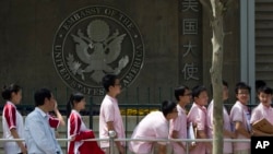 FILE - Chinese students wait outside the U.S. Embassy for their visa application interviews on May 2, 2012, in Beijing. The Chinese government has protested to the United States over the treatment of Chinese arriving to study in America.