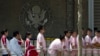 FILE - Chinese students wait outside the U.S. Embassy for their visa application interviews, May 2, 2012, in Beijing. 