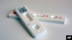 FILE - COVID-19 antigen home tests indicating a positive result are photographed in New York, April 5, 2023. The Biden administration has announced that it is providing $600 million in funding to produce new, free at-home COVID-19 tests.