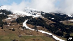 FILE - A strip of snow makes a ski slope in Saalbach, Austria, March 17, 2024. The U.N. weather agency is sounding “a red alert” about global warming last year and beyond.