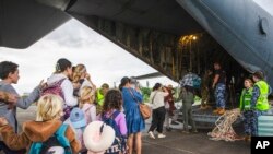 Turis Australia dan lainnya menaiki Hercules Angkatan Udara Australia saat bersiap berangkat dari Bandara Magenta di Noumea, Kaledonia Baru, Selasa, 21 Mei 2024. (LAC Adam Abela/Royal Australian Airfare via AP)