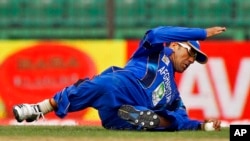 FILE - Afghanistan's Karim Sadiq dives to catch the ball while fielding during the Asia Cup one-day international cricket tournament against Pakistan in Fatullah, near Dhaka, Bangladesh, Feb. 27, 2014. 