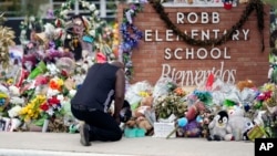 FILE - Reggie Daniels pays his respects at a memorial at Robb Elementary School, June 9, 2022, in Uvalde, Texas. The 19 fourth-graders and two teachers killed at the school were remembered May 24, 2024, on the second anniversary of the shootings. 