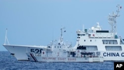 FILE - A Chinese coast guard ship blocks a Philippine coast guard ship as it maneuvers to enter the mouth of the Second Thomas Shoal, locally known as Ayungin Shoal, in one of the world's most hotly contested passages in the South China Sea, April 23, 2023. 