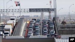 FILE - Cars and trucks line up to enter the US from Mexico at a border crossing in El Paso, Texas, March 29, 2019.