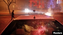 FILE - A girl sits inside the car as firecrackers and fireworks explode celebrating the start of the Chinese Lunar New Year in Beijing just before midnight February 7, 2016. (REUTERS/Damir Sagolj)