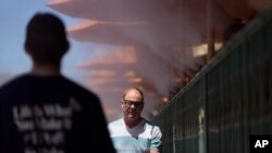 People walk through cooling misters along the Las Vegas Strip, June 4, 2024, in Las Vegas, Nevada. 